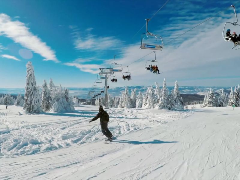 prikaz ski staze na kopaoniku i momka koji vozi snowboard